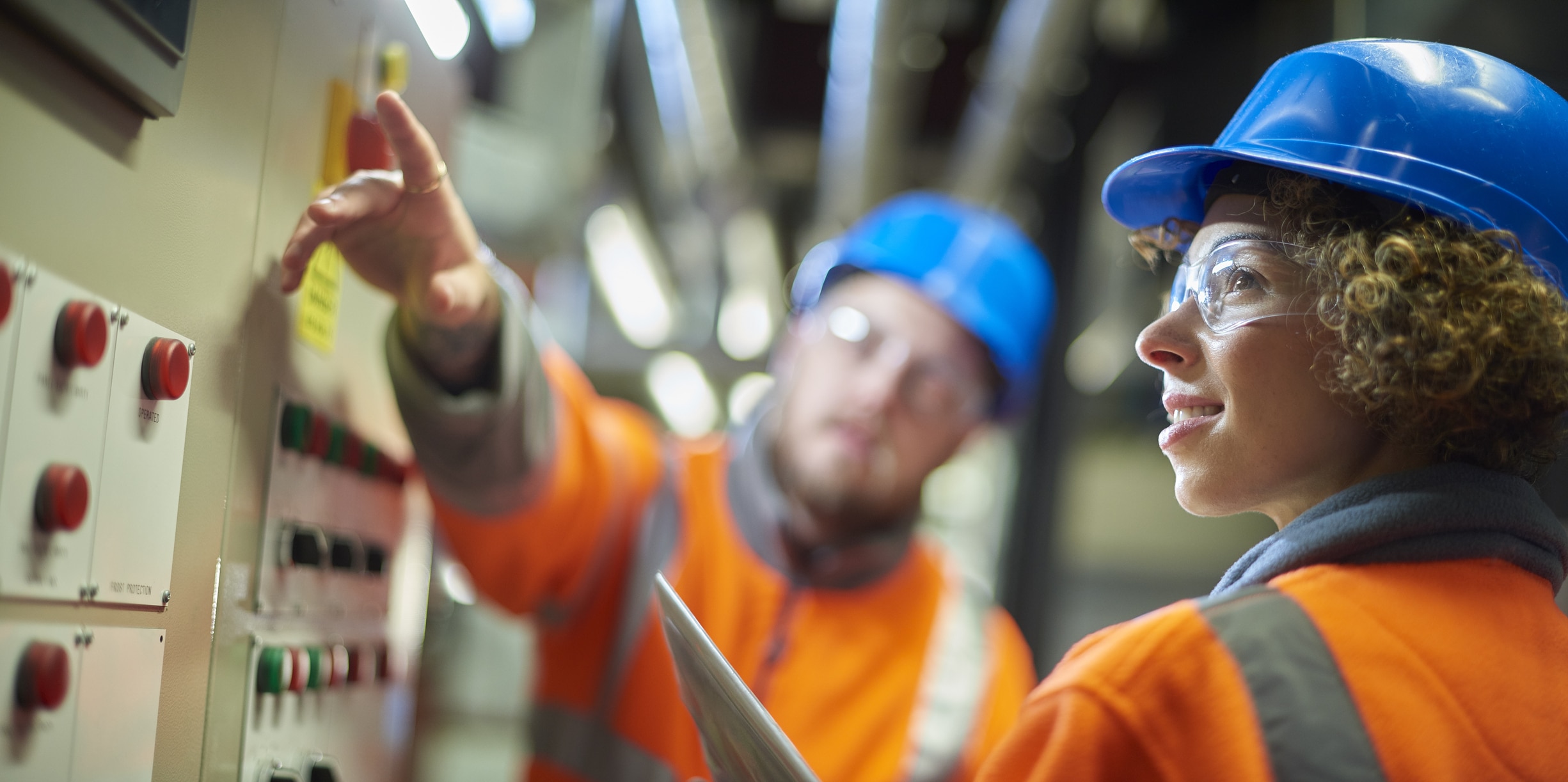 Types of employee engagement with manager in caution gear and hard hats training an individual in a boiler room.