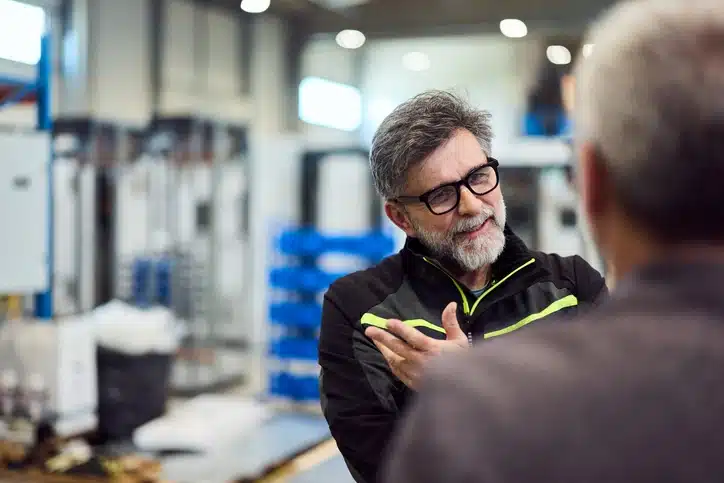Blue collar workers using empathy in leadership while communicating in workplace.