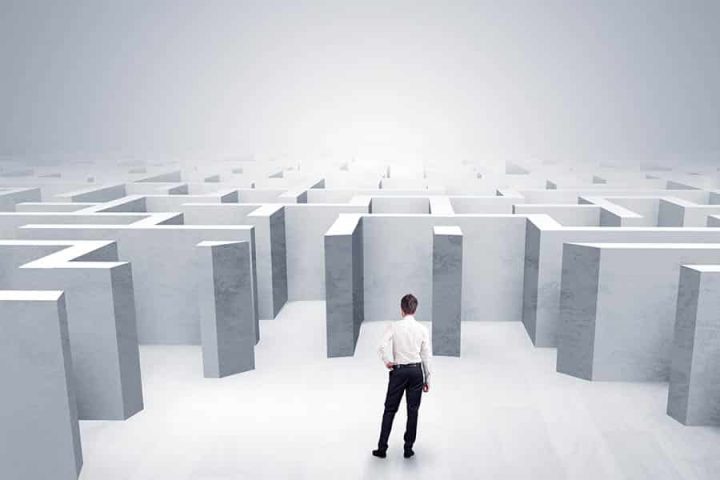 Man in business attire stares at maze to walk in and lead in a crisis.