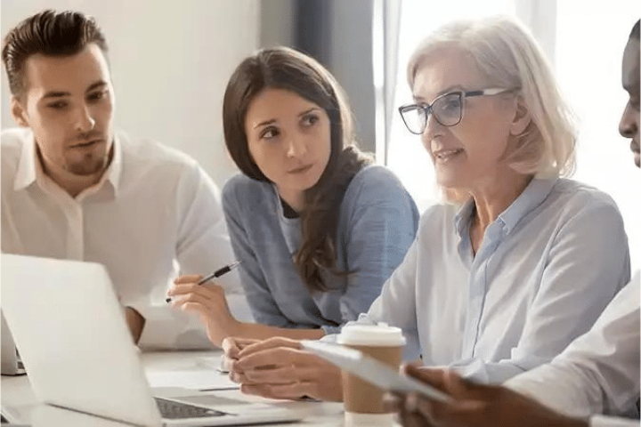 Work environment of employees at a table during a meeting.