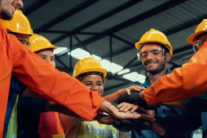Teamwork and collaboration as co workers huddle in with hands in pile.